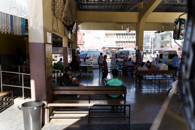 คนนั่งรอขึ้นรถที่ บขส. กาญจนบุรี